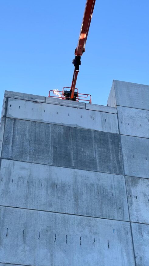 Boom lift at the top of a precast concrete wall, sealing horizontal and vertical joints, Guildford car park
