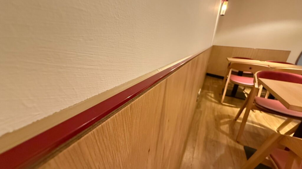 Red trim along oak wall panelling in a café seating area