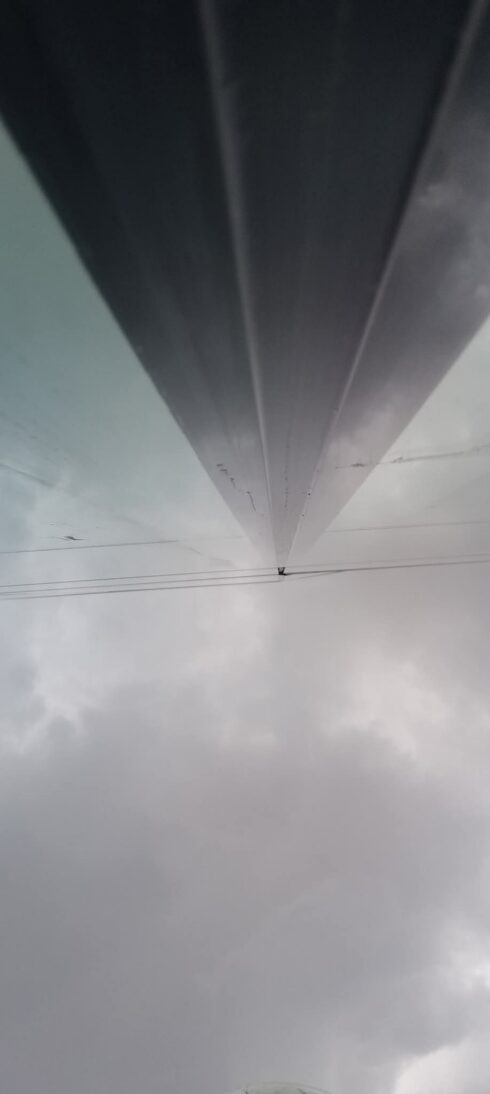 Underside of a dark grey glazing mullion, looking up