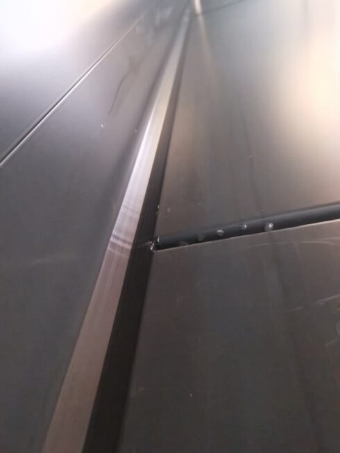 Sealed joints between dark grey metal cladding panels