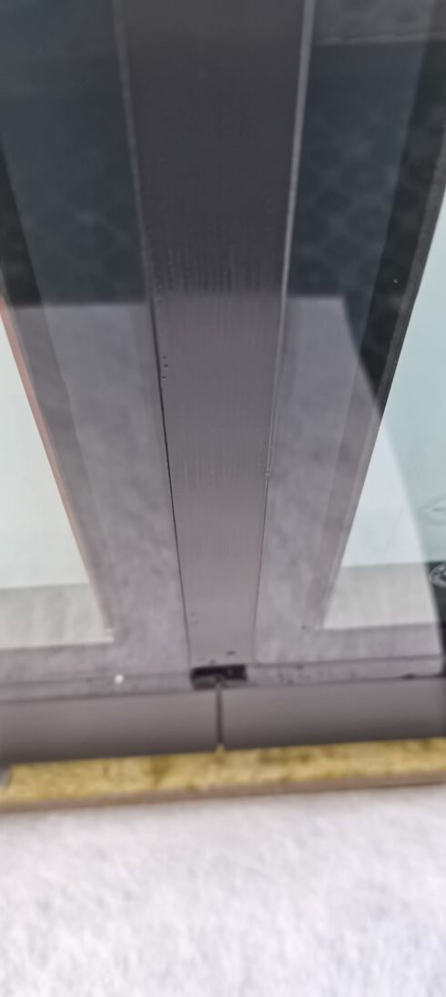 Dark grey glazing mullion meeting the sill