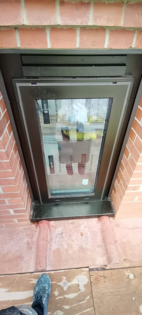 Grey aluminium window in red brickwork with the frame perimeter sealed