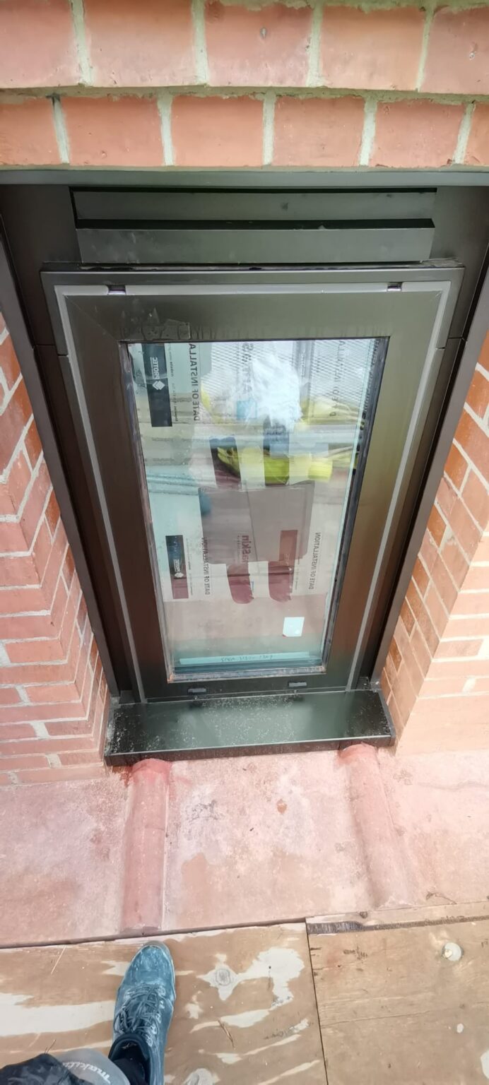 Grey aluminium window in red brickwork with the frame perimeter sealed
