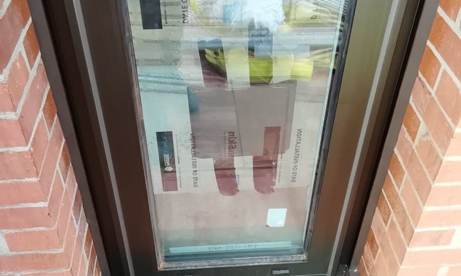 Grey aluminium window in red brickwork with the frame perimeter sealed