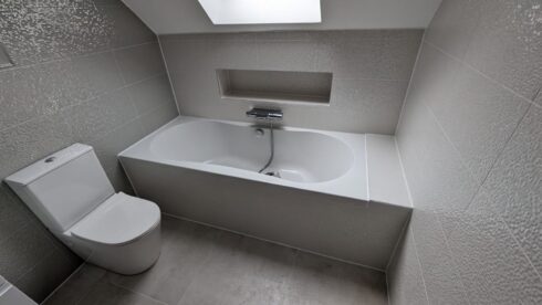 Loft bathroom with built-in bath, recessed shelf and toilet, sealed around the bath, Bedford