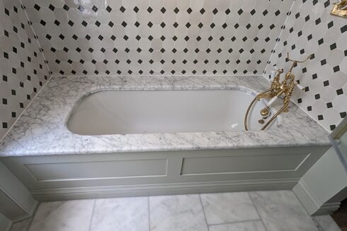 Built-in bath with marble deck, gold taps and black and white tiles, sealed, Bedford