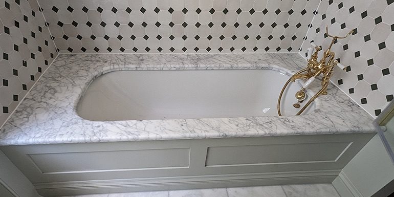 Built-in bath with marble deck, gold taps and black and white tiles, sealed, Bedford