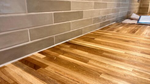 Silicone joint between an oak worktop and grey metro tile splashback