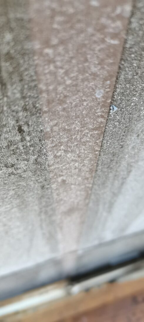 Close-up of a sealed vertical joint in pale stone cladding