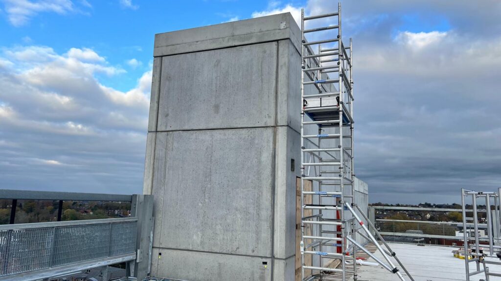 Precast concrete core at roof level with a tower scaffold for sealing panel joints