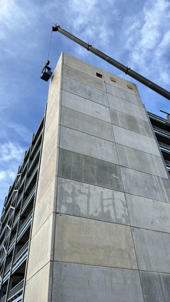 Precast concrete stair core with a crane, panel joints being sealed
