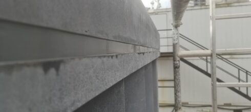 Close-up of a grey sealant joint under a stone coping