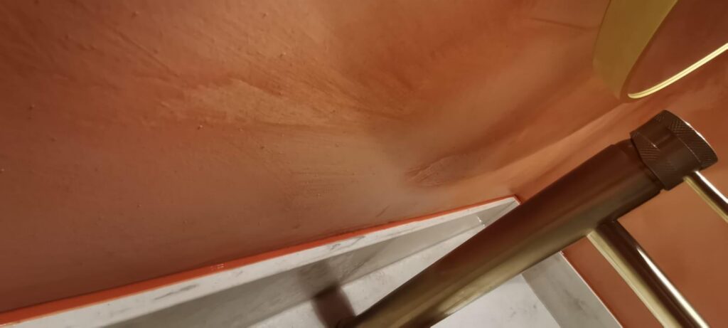 Terracotta-coloured sealant matched to a plastered wall where it meets a white marble top
