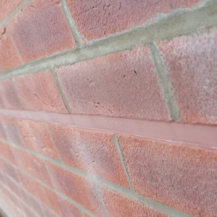 Brick-red sealant in a horizontal movement joint in red brickwork