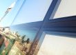 Curtain wall glazing with dark grey framing reflecting a city skyline