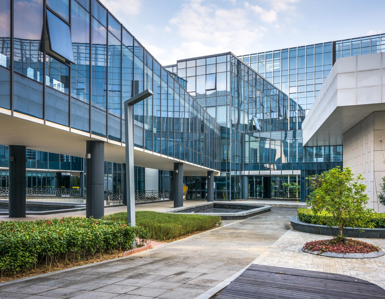 Glass-fronted modern office buildings around a landscaped courtyard