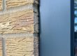 After: neat new grey sealant joint between an anthracite window frame and buff brick, Bedford