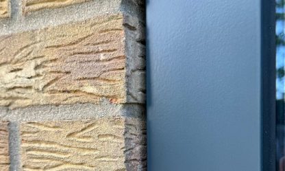 After: neat new grey sealant joint between an anthracite window frame and buff brick, Bedford